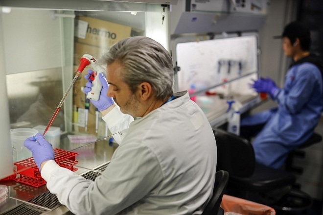 Một nhà khoa học đang tiến hành điều chế vaccine chống lại dịch Covid-19. Ảnh: AFP